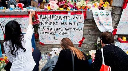 People read and pay tribute at a memorial along Yonge Street, in Toronto, the day after a driver drove a van down sidewalks, striking and killing numerous pedestrians in his path. (AP)