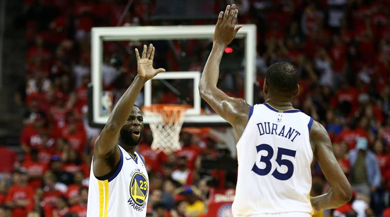 Golden State Warriors forward Draymond Green (23) and forward Kevin Durant (35) high-five in the final seconds of the forth quarter against the Houston Rockets in game seven of the Western conference finals of the 2018 NBA Playoffs