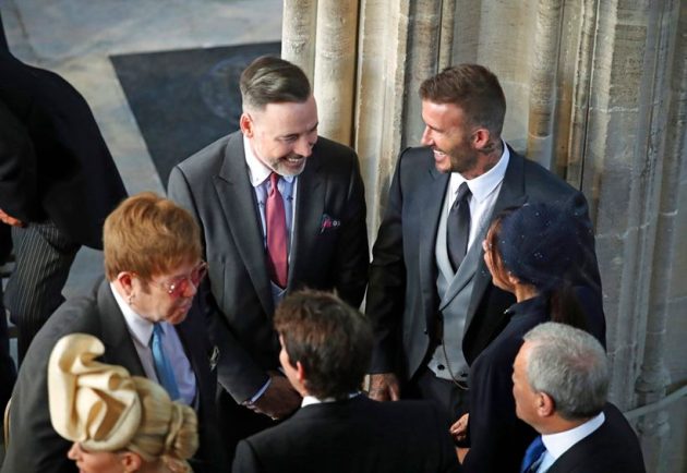 David and Victoria Beckham talk with Sir Elton John at royal wedding