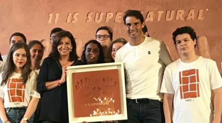 Paris Mayor Anne Hidalgo, left, presents Rafael Nadal, right, with framed handprints bearing 11 fingers in a nod to the 11th French Open titles he won, during a ceremony held at the Paris city hall