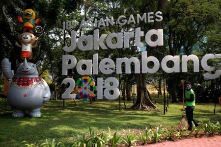 FILE PHOTO: A worker cleans near a sign for the upcoming 2018 Asian Games, which would be held in both Jakarta and Palembang, Sumatra, in Jakarta, Indonesia September 17, 2017.  REUTERS/Darren Whiteside/File Photo
