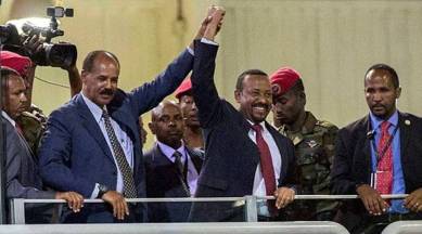 Eritrean President Isaias Afwerki (second left) and Ethiopia's Prime Minister Abiy Ahmed (centre) hold hands as they wave at the crowds in Addis Ababa, Ethiopia on Sunday. (AP)
