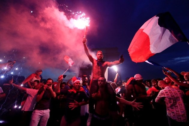 France fans celebrate in front of the Arc de Triomphe on the Champs-Elysees Avenue after France won the Soccer World Cup final.