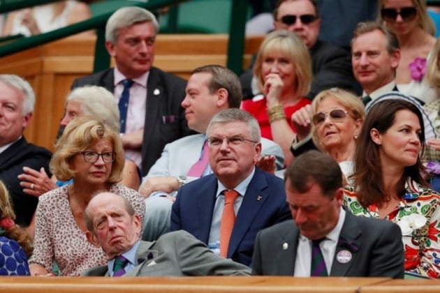 IOC President Thomas Bach watches Spain's Rafael Nadal continue his semi final match against Serbia's Novak Djokovic, which was suspended yesterday, after running late
