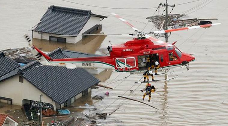 A resident is rescued in a flooded area in Kurashiki on Sunday. (AP)