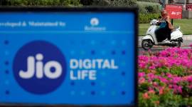 A woman rides her scooter past advertisements of Reliance Industries’ Jio telecoms unit, in Ahmedabad A Jio advertisement