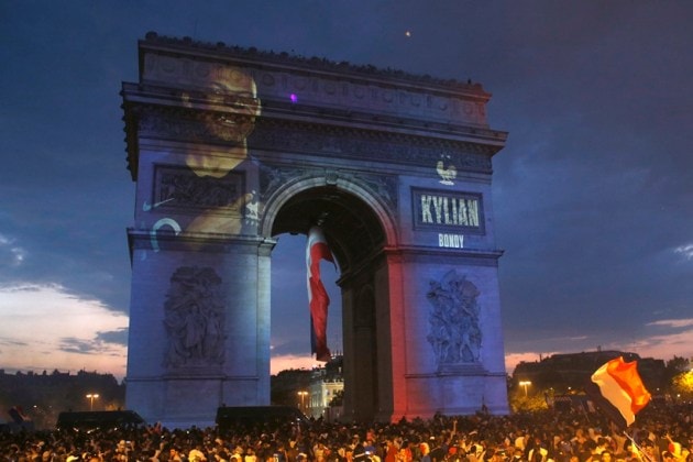 The name of French soccer player Kylian Mbappe is projected onto the Arc de Triomphe as soccer fans invade the Champs Elysees avenue after France won the soccer World Cup final match between France and Croatia
