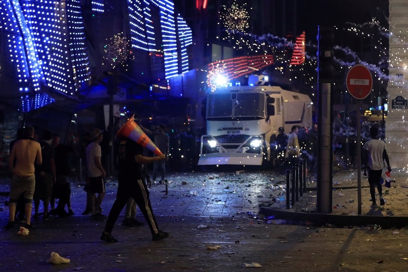 French CRS riot police advance during clashes on the Champs-Elysees after France win the Soccer World Cup final