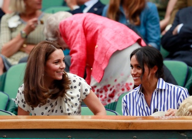 Kate, Duchess of Cambridge and Meghan, Duchess of Sussex, right, sit in the Royal Box on Centre Court at Wimbledon