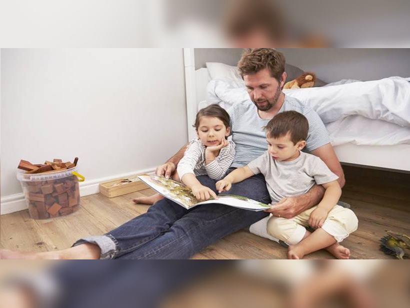 Father Reading Story To Children In Their Bedroom
