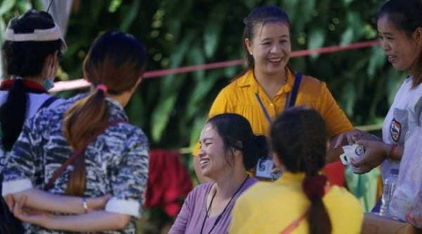 Family members pass time near the Tham Luang cave complex, where members of an under-16 soccer team and their coach have been found alive