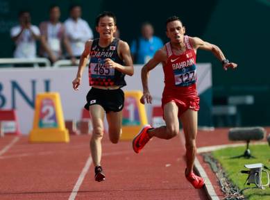 Bahrain's Elhassan Elabbassi, right, stumbles as he sprints to the finish line with Japan's Hiroto Inoue in the men's marathon at the 18th Asian Games in Jakarta, Indonesia