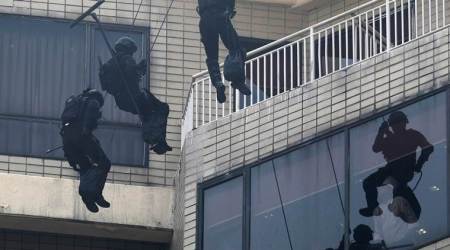 A chef watches as Indonesia Kopassus special forces soldiers hang from the top of Sultan Hotel during an anti-terror drill ahead of the upcoming Asian Games in Jakarta, Indonesia August 1, 2018. REUTERS/Beawiharta