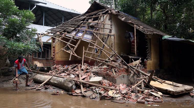 A man removes debris from a collapsed house