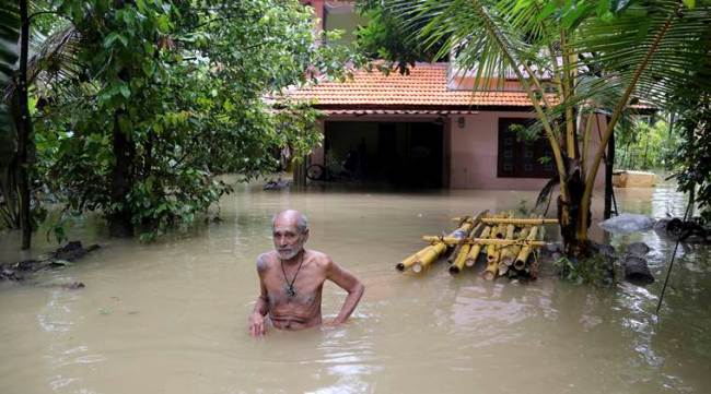 Man wades through flooded home in Kerala