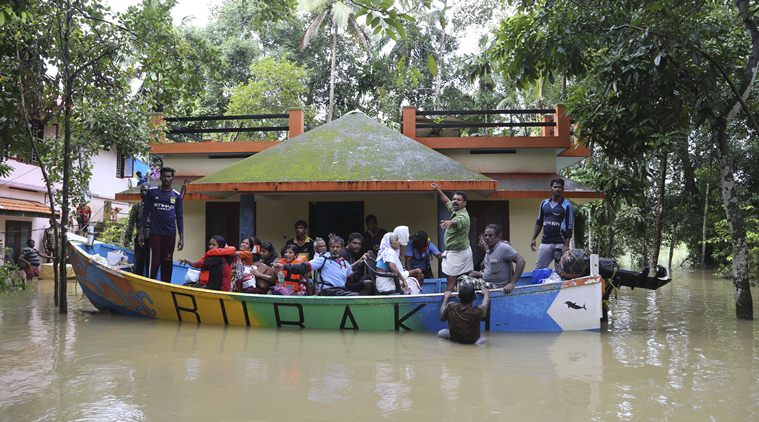 Volunteers rescue stranded people in a boat from a flooded area in Chengannur in Kerala. (AP)