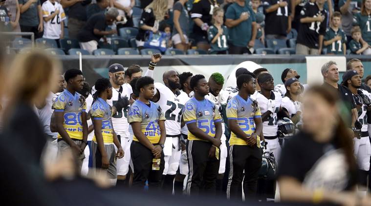 Philadelphia Eagles' Malcolm Jenkins, center left, raises his fist during the national anthem before the team's preseason NFL football game against the Pittsburgh Steelers.