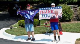 Supporters of Donald Trump hold up placards thanking him