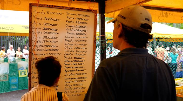 People check prices of fruits and vegetables in a street market in Caracas.