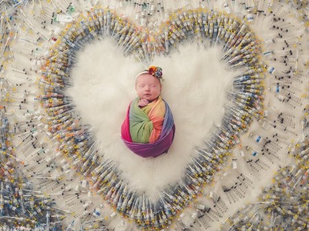 This photo of a baby surrounded by syringes is going viral on social media. (Source: Packer Family Photography/Facebook)
