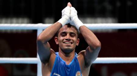 Amit Panghal celebrates after defeating Uzbekistan's Dusmatov Hasanboy in their men's light flyweight boxing final at the 18th Asian Games in Jakarta, Indonesia