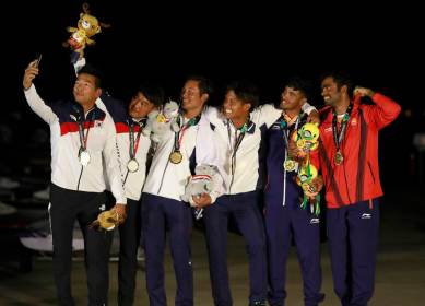 From left to right silver medalist Chae Bonjin and Kim Dongwook of Korea, gold medalist Shingen Furuya and Shinji Hachiyama of Japan and bronze medalist Varun Ashokthakkar and Kelapanda Chengappa of India pose for a selfie with their medals during the victory ceremony for in the 49er Men of sailing event at the18th Asian Games in Jakarta, Indonesia