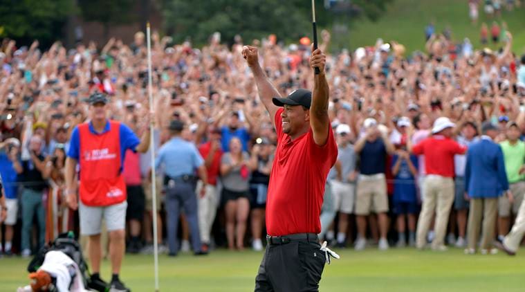 Tiger Woods celebrates after picking up his putt for par on the 18th green to win the final round of the Tour Championship golf tournament Sunday, Sept. 23, 2018, in Atlanta.