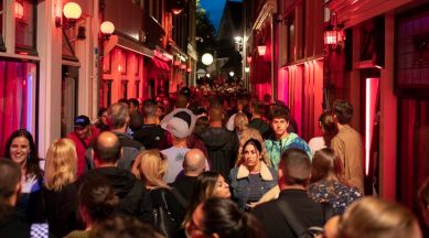 Visitors walk through a packed alley in the Red Light district in Amsterdam, Aug. 11, 2018. City officials have introduced measures — including on-the-spot fines for public urination and drunkenness — to try to improve the behavior of visitors. (Jasper Juinen The New York Times)