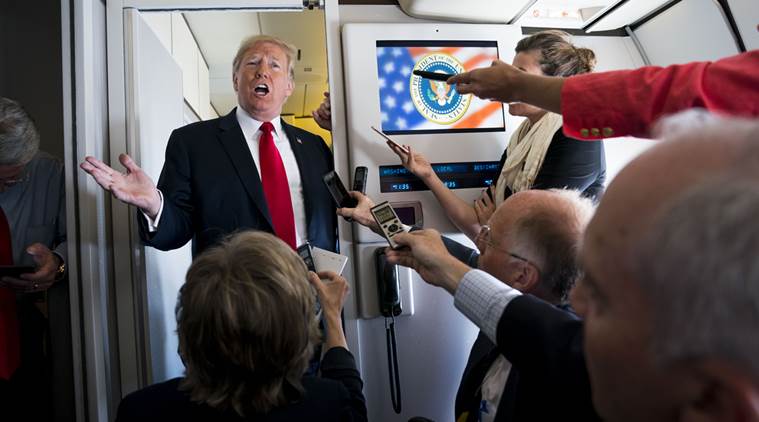 President Donald Trump speaks to reporters aboard Air Force One