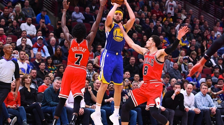 Golden State Warriors guard Klay Thompson (11) shoots the ball against Chicago Bulls forward Justin Holiday (7) and guard Zach LaVine (8) during the second half at the United Center.