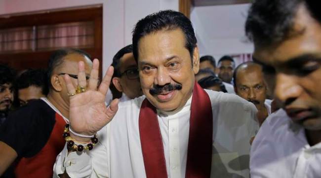 Colombo: Newly appointed Sri Lankan Prime Minister Mahinda Rajapaksa, center, leaves a Buddhist temple after meeting his supporters in Colombo, Sri Lanka, Friday, Oct. 26, 2018. Sri Lankan President Maithripala Sirisena has sacked the country's prime minister and replaced him with a former strongman, state television said Friday. AP/PTI(AP10_26_2018_000218A)