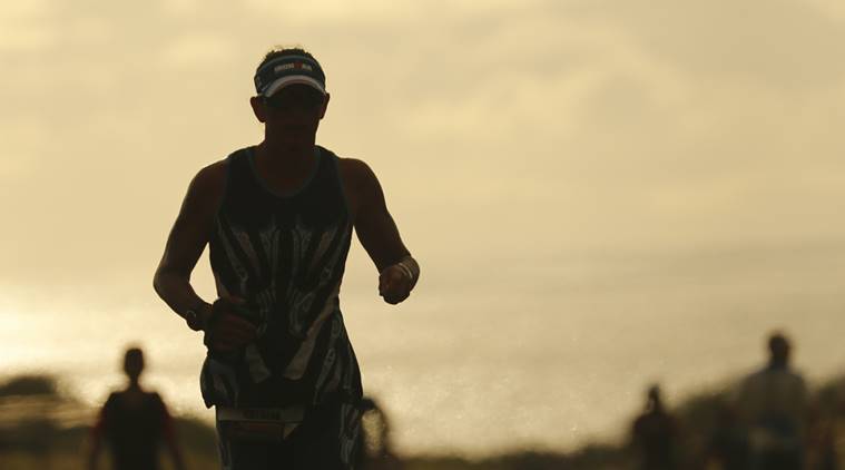 Athletes make their way down the course at sunset during the marathon at the Ironman World Championship Triathlon, Saturday, Oct. 13, 2018, in Kailua-Kona, Hawaii.