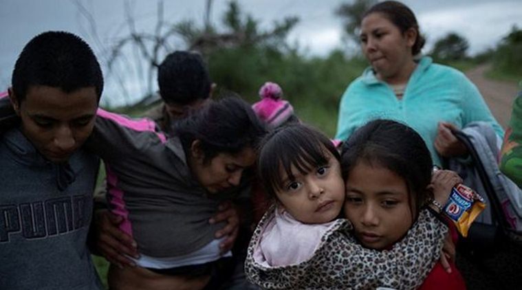 Crystal, 5, of Honduras, is held by her sister after a group of two dozen families members raced away from what border patrol agents said were gunshots near the site where they illegally crossed the Rio Grande river into the United States from Mexico in Fronton, Texas. (Reuters)