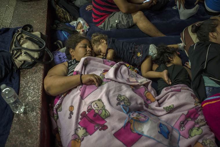 Lindell Marroquin of La Ceiba, Honduras, rests with her two daughters at a school in Guatemala City.