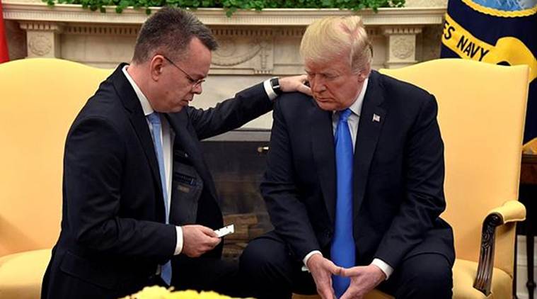 US President Donald Trump closes his eyes in prayer along with Pastor Andrew Brunson, after his release from two years of Turkish detention, in the Oval Office of the White House, Washington. (Reuters)