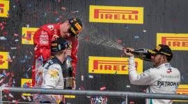 Ferrari driver Kimi Raikkonen (center) of Finland celebrates winning the United States Grand Prix at Circuit of the Americas with Red Bull Racing driver Max Verstappen (left) of Netherlands and Mercedes driver Lewis Hamilton (right) of Great Britain