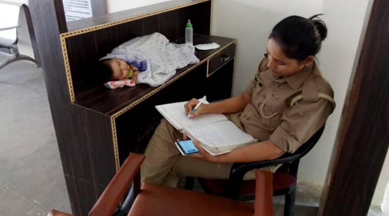 Uttar Pradesh police, woman constable with baby, Up news, Woman constable at work with baby, woman police with baby transferred, Indian express