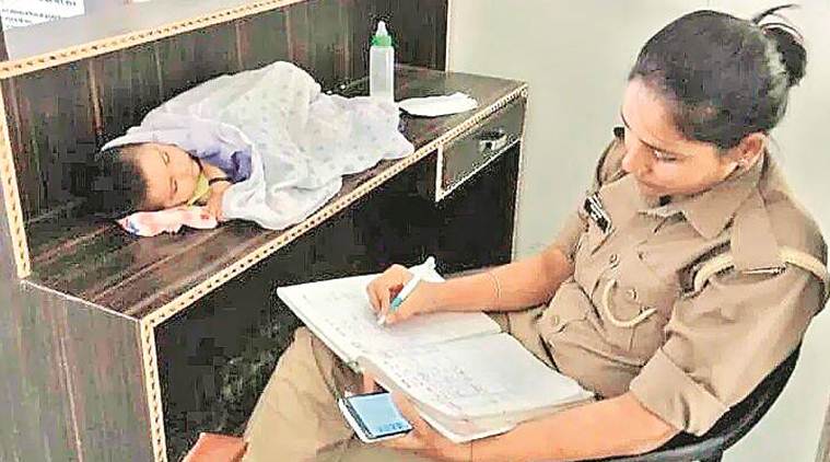 Uttar Pradesh police, woman constable with baby, Up news, Woman constable at work with baby, woman police with baby transferred, Indian express