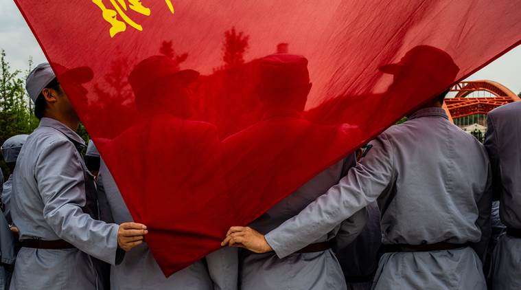 Aerospace workers, wearing Long March-style uniforms, hold a flag