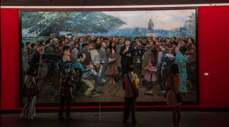 Visitors look at a painting of Xi Jinping