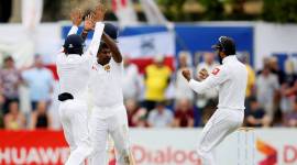 Sri Lanka's Rangana Herath (C) celebrates with Kusal Mendis (L) and captain Dinesh Chandimal after taking the wicket of England's captain Joe Root