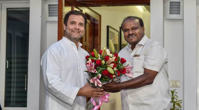New Delhi: JD(S) leader and Karnataka chief minister-designate H D Kumaraswamy presents a bouquet to Congress President Rahul Gandhi, during a meeting at latter's residence, in New Delhi, on Monday. Former Congress president Sonia Gandhi is also seen. (PTI Photo/Manvender Vashist)(PTI5_21_2018_000190B)