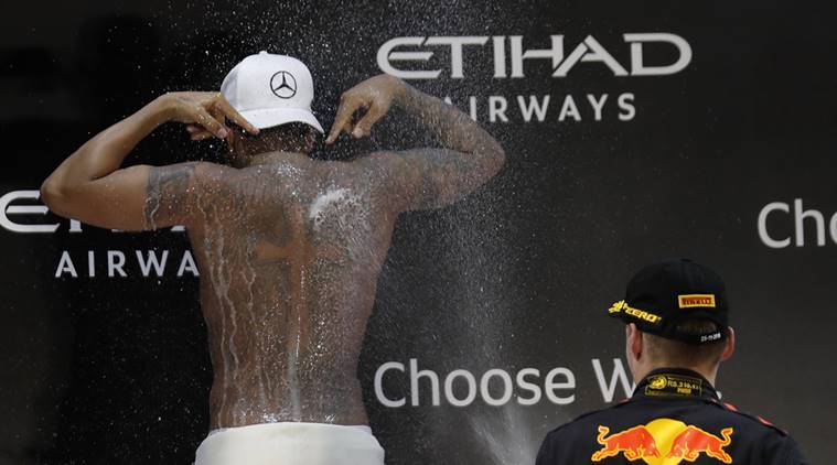 Third placed Red Bull driver Max Verstappen of the Netherlands, right, sprays champagne on race winner Mercedes driver Lewis Hamilton of Britain after the Emirates Formula One Grand Prix at the Yas Marina racetrack in Abu Dhabi, United Arab Emirates