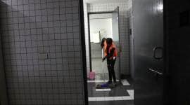The boy cleaning the toilet at Thyagaraj Stadium. (Express photo by Abhinav Saha)