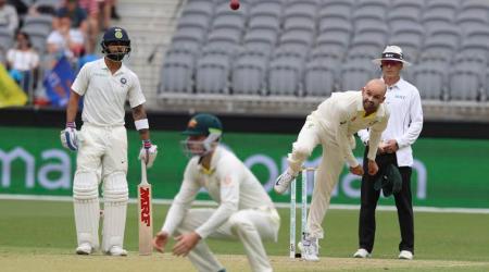 Australia's Nathan Lyon bowls watched by India's Virat Kohli (left) and Australia's Peter Handscomb during play in the second cricket test between Australia and India in Perth, Australia, Saturday, Dec. 15, 2018. (AP Photo/Trevor Collens)
