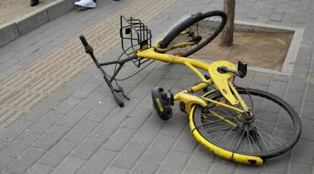 An Ofo bike-sharing bicycle is locked for personal use at a bus station on the outskirts of Beijing.