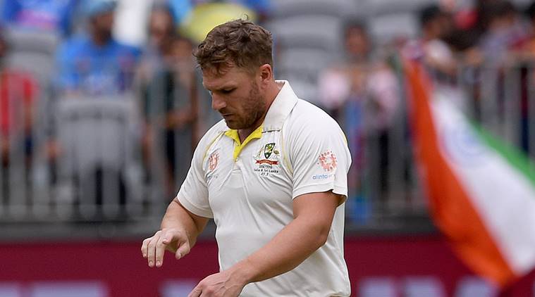 Australia's Aaron Finch looks at his injured finger before retiring hurt, on day three of the second test match between Australia and India, at Perth Stadium in Perth, Australia
