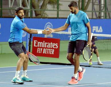 Indian pair Rohan Bopanna (R) and Divij Sharan celebrate after defeating Radu Albot-Malek Jaziri pair, in the Men's double of the first round on Day two during the Tata Open Maharashtra at Mhalunge Balewadi Tennis Stadium