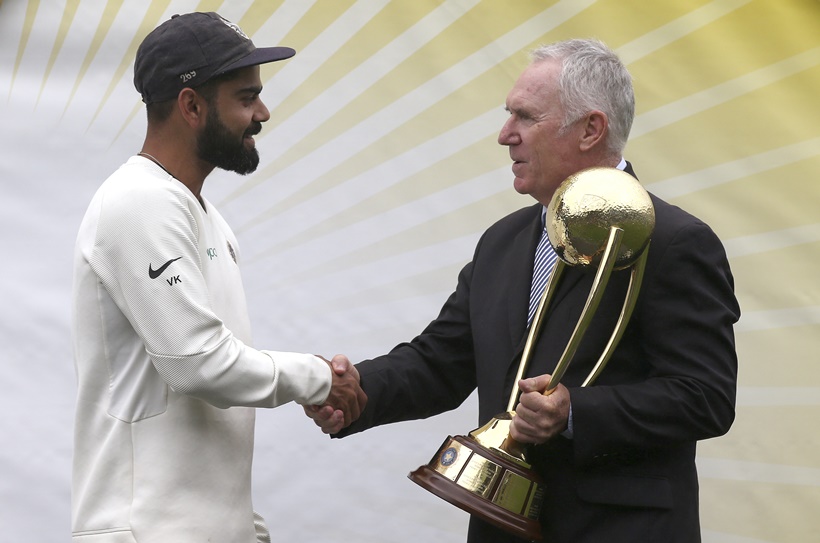 India's Virat Kohli, left, is presented the Border–Gavaskar Trophy by Allan Border after their series win over Australia after play was called off on day 5 of their cricket test match in Sydney