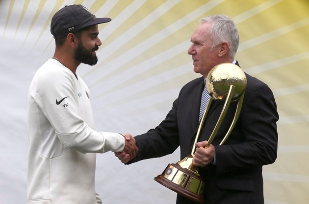 India's Virat Kohli, left, is presented the Border–Gavaskar Trophy by Allan Border after their series win over Australia after play was called off on day 5 of their cricket test match in Sydney